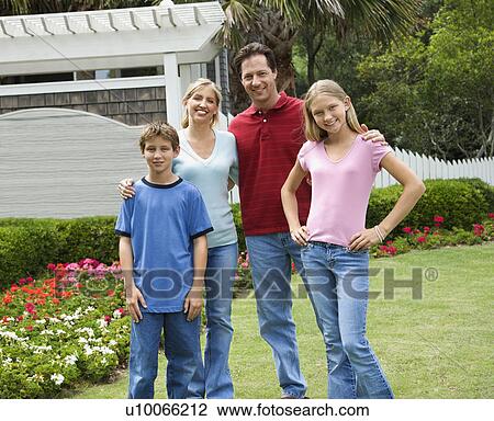 Caucasian family of four posing for portrait in yard. View Large Photo Image Stock Image - Caucasian family of four posing for portrait in yard.. Fotosearch