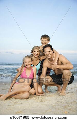 Caucasian family of four posing together on beach. View Large Photo Image Stock Photography - Caucasian family of four posing together on beach.. Fotosearch