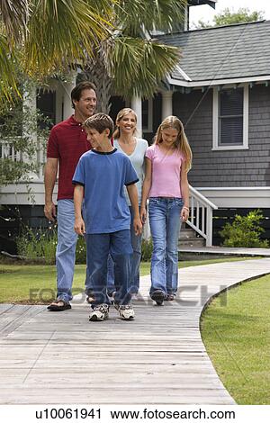 Caucasian family of four walking down suburban sidewalk with house in background. View Large Photo Image Stock Image - Caucasian family of four walking down suburban sidewalk with house in background.. Fotosearch