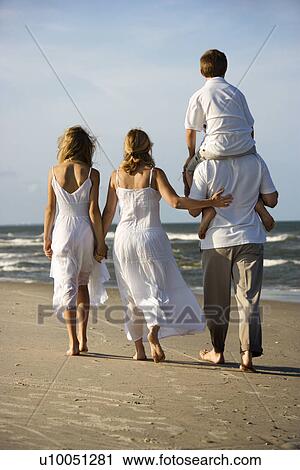 Caucasian family of four walking on beach with dad carrying son on shoulders. View Large Photo Image Stock Image - Caucasian family of four walking on beach with dad carrying son on shoulders.. Fotosearch