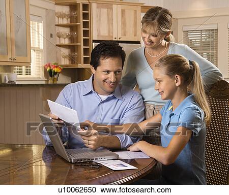 Stock Image - Caucasian family paying bills on laptop computer.. Fotosearch