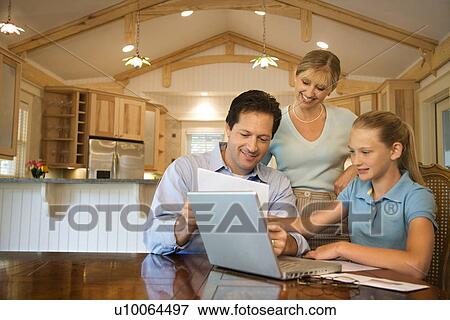 Stock Photo - Caucasian family paying bills on laptop computer.. Fotosearch