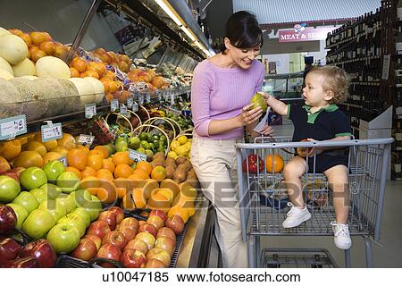 Caucasian mid-adult woman grocery shopping for fruit with young male toddler. View Large Photo Image Stock Photography - Caucasian mid-adult woman grocery shopping for fruit with young male toddler.. Fotosearch