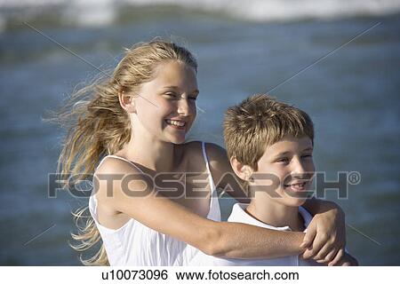 Caucasian pre-teen girl with arms around pre-teen boy on beach. View Large Photo Image Stock Photograph - Caucasian pre-teen girl with arms around pre-teen boy on beach.. Fotosearch
