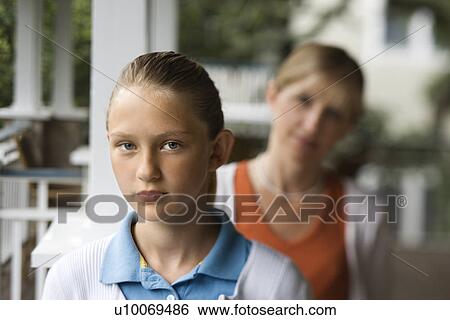 Caucasian pre-teen girl with mother behind her looking over shoulder. View Large Photo Image Stock Photograph - Caucasian pre-teen girl with mother behind her looking over shoulder.. Fotosearch