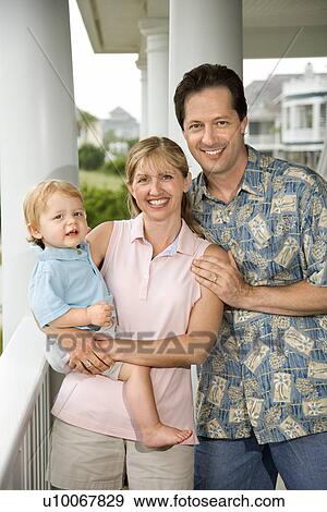 Stock Photo - Family portrait of Caucasian mid-adult man and woman with male toddler.. Fotosearch