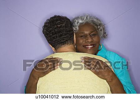 Stock Image - Mature adult African American females embracing.. Fotosearch