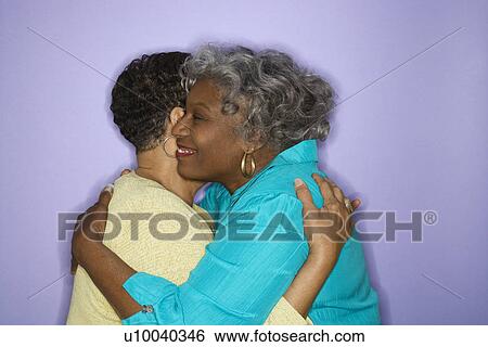 Stock Photograph - Mature adult African American females embracing.. Fotosearch