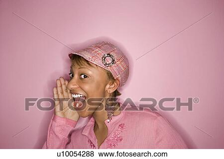 Portrait of smiling young African-American adult woman on pink background yelling and smiling at unseen person. View Large Photo Image Stock Photo - Portrait of smiling young African-American adult woman on pink background yelling and smiling at unseen person.. Fotosearch