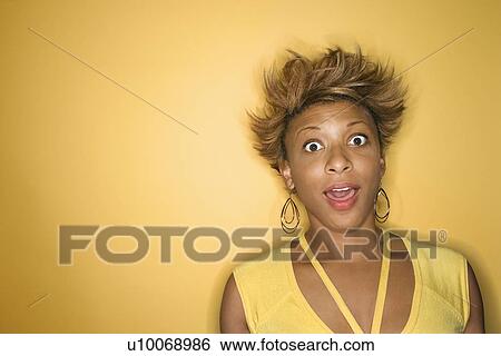 Portrait of surprised African-American young adult woman on yellow background. View Large Photo Image Stock Photograph - Portrait of surprised African-American young adult woman on yellow background.. Fotosearch