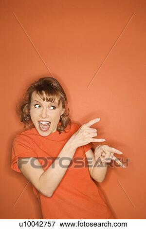 Smiling Caucasian mid-adult woman gesturing on orange background. View Large Photo Image Stock Photo - Smiling Caucasian mid-adult woman gesturing on orange background.. Fotosearch