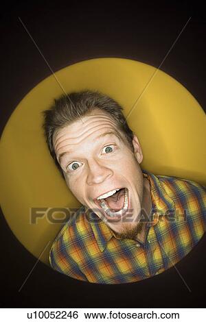 Vignette of adult Caucasian man on yellow background making funny face at viewer. View Large Photo Image Stock Photograph - Vignette of adult Caucasian man on yellow background making funny face at viewer.. Fotosearch