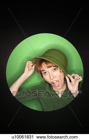 Vignette of Caucasian mid-adult woman tilting hat on green background. View Large Photo Image Stock Image - Vignette of Caucasian mid-adult woman tilting hat on green background.. Fotosearch