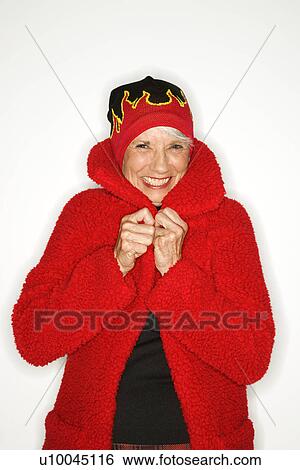 Stock Photograph - Caucasian mature adult female in coat and flame hat.. Fotosearch