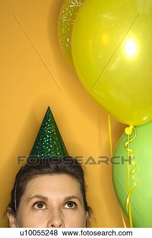 Stock Photo - Caucasian prime adult female wearing party hat.. Fotosearch