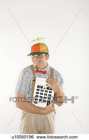 Caucasian young man dressed like nerd wearing beanie and smiling while holding large calculator. View Large Photo Image Stock Photograph - Caucasian young man dressed like nerd wearing beanie and smiling while holding large calculator.. Fotosearch