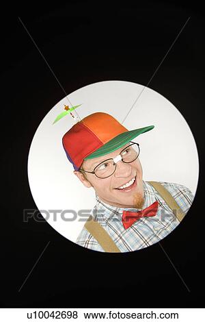 Stock Photo - Close up circle vignett of Caucasian young man dressed like nerd wearing propeller hat looking mischievous.. Fotosearch