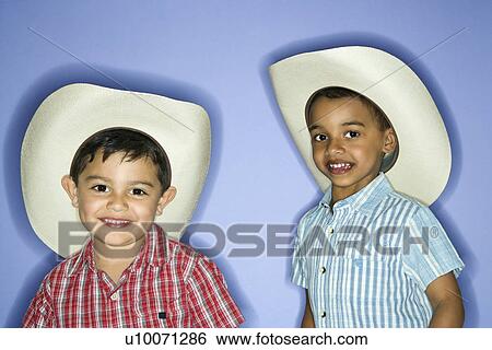 Stock Photograph - Hispanic and African American male child in cowboy hats.. Fotosearch
