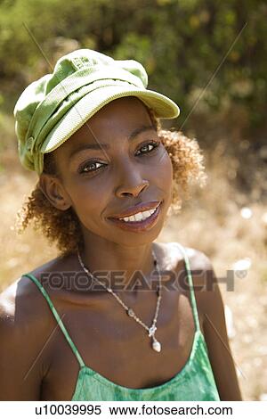 Stock Photography - MId-adult Black female wearing cap and making eye contact.. Fotosearch