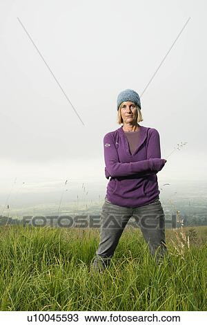 Middle-aged Caucasian woman standing alone in field. View Large Photo Image Stock Image - Middle-aged Caucasian woman standing alone in field.. Fotosearch