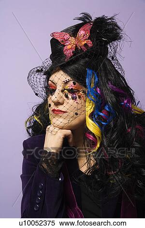 Portrait of Caucasian woman in unique makeup and clothing against purple background. View Large Photo Image Stock Photography - Portrait of Caucasian woman in unique makeup and clothing against purple background.. Fotosearch