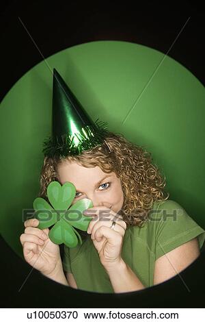 Vignette of young adult Caucasian woman on green background wearing Saint Patricks Day hat and holding shamrock. View Large Photo Image Stock Image - Vignette of young adult Caucasian woman on green background wearing Saint Patricks Day hat and holding shamrock.. Fotosearch