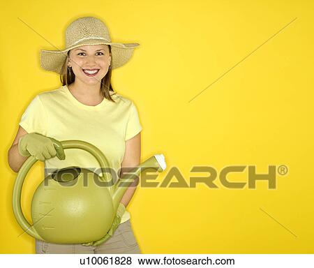 Young adult female Caucasian holding watering can wearing straw hat. View Large Photo Image Stock Photo - Young adult female Caucasian holding watering can wearing straw hat.. Fotosearch