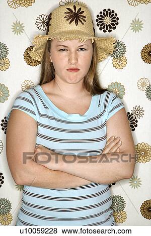 Stock Photo - Young Caucasian woman pouting wearing straw hat.. Fotosearch