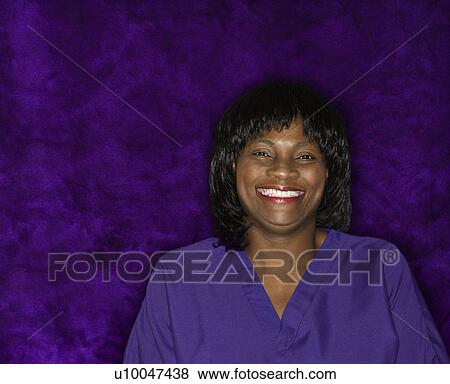 Stock Photo - African-American mid-adult woman in medical uniform smiling.. Fotosearch