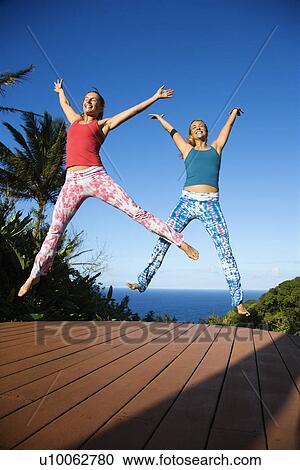 Caucasian mid-adult women jumping into air with arms and legs outstretched. View Large Photo Image Stock Image - Caucasian mid-adult women jumping into air with arms and legs outstretched.. Fotosearch