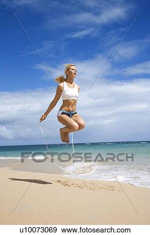 Caucasian young adult woman jumping rope on beach. View Large Photo Image Stock Photo - Caucasian young adult woman jumping rope on beach.. Fotosearch