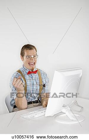 Caucasian young man dressed like nerd excited looking at computer monitor. View Large Photo Image Stock Photograph - Caucasian young man dressed like nerd excited looking at computer monitor.. Fotosearch