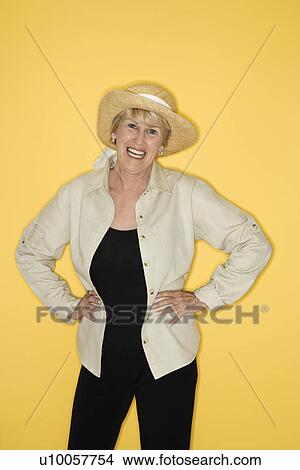 Picture - Caucasian mature adult female with hands on hips smiling.. Fotosearch