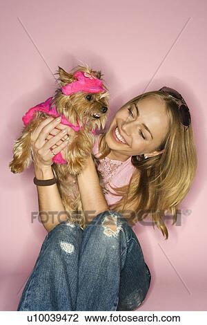 Stock Image - Caucasian young adult female holding Yorkshire Terrier dog.. Fotosearch