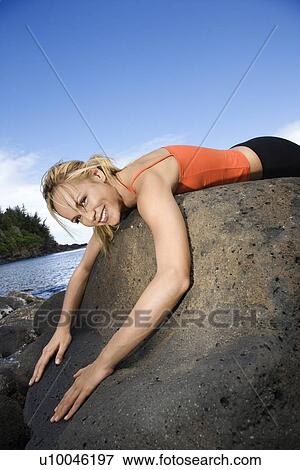 Caucasian young adult woman draped over large rock. View Large Photo Image Stock Photo - Caucasian young adult woman draped over large rock.. Fotosearch