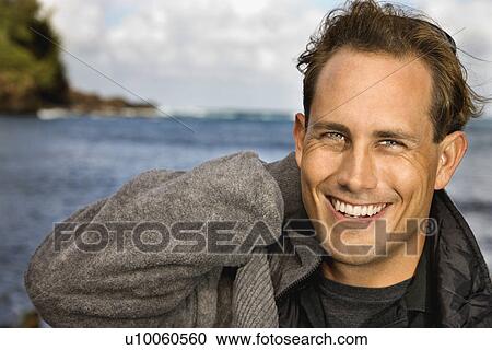 Caucasion mid-adult man looking at viewer, smiling, by ocean in Maui, Hawaii. View Large Photo Image Stock Image - Caucasion mid-adult man looking at viewer, smiling, by ocean in Maui, Hawaii.. Fotosearch