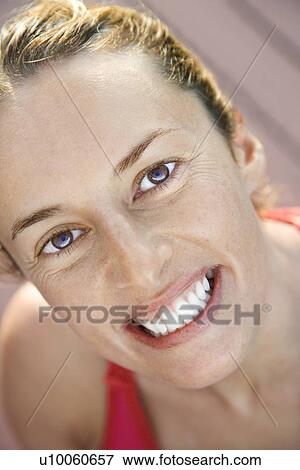 Stock Photo - Close-up of Caucasian mid-adult woman smiling and looking at viewer.. Fotosearch