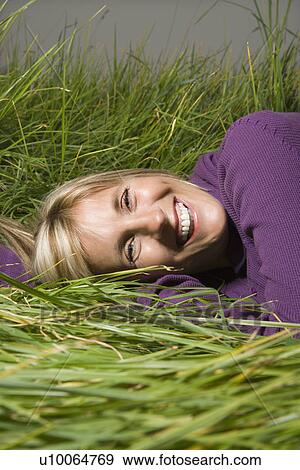 Middle-aged Caucasian woman lying in grass laughing. View Large Photo Image Stock Photo - Middle-aged Caucasian woman lying in grass laughing.. Fotosearch