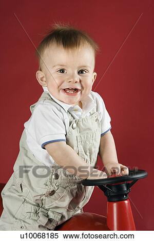Stock Photography - Portrait of Caucasian male child driving play car.. Fotosearch