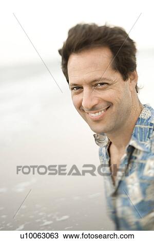 Portrait of Caucasian mid-adult man on beach looking at viewer smiling. View Large Photo Image Stock Image - Portrait of Caucasian mid-adult man on beach looking at viewer smiling.. Fotosearch