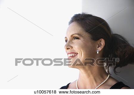 Stock Photo - Portrait of mid-adult Caucasian female smiling and looking to side.. Fotosearch