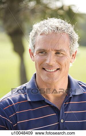 Stock Photo - Portrait of mid-adult male with gray hair looking off to side.. Fotosearch