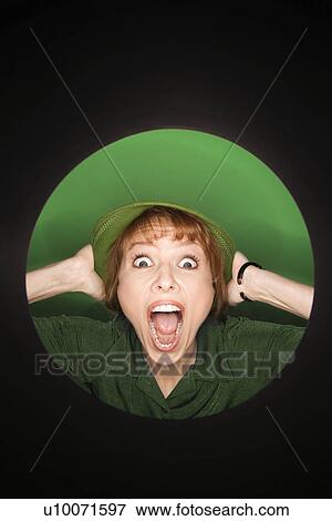 Vignette of Caucasian mid-adult woman with surprised expression wearing hat on green background. View Large Photo Image Stock Photo - Vignette of Caucasian mid-adult woman with surprised expression wearing hat on green background.. Fotosearch