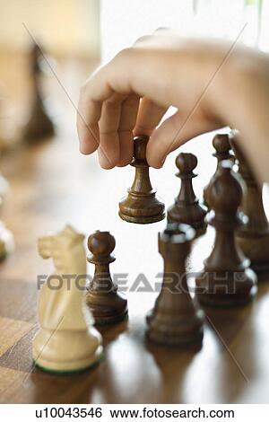 Stock Photograph - Caucasian person hand moving chess piece.. Fotosearch