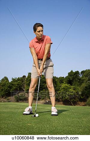 Caucasion mid-adult woman putting golf ball. View Large Photo Image Stock Photo - Caucasion mid-adult woman putting golf ball.. Fotosearch