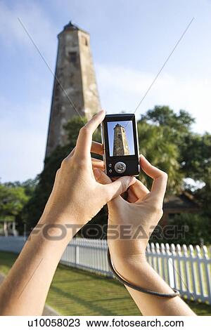 Close up of Caucasian woman's hands holding digital camera and photographing lighthouse at Bald Head Island, North Carolina. View Large Photo Image Stock Image - Close up of Caucasian woman's hands holding digital camera and photographing lighthouse at Bald Head Island, North Carolina.. Fotosearch