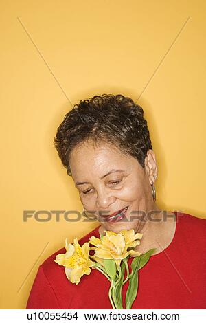 African American mature adult female holding flowers. View Large Photo Image Picture - African American mature adult female holding flowers.. Fotosearch