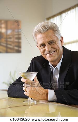 Caucasian mature adult male sitting at bar with martini smiling. View Large Photo Image Stock Image - Caucasian mature adult male sitting at bar with martini smiling.. Fotosearch