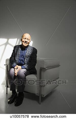 Stock Photo - Caucasian mature adult male sitting in chair.. Fotosearch