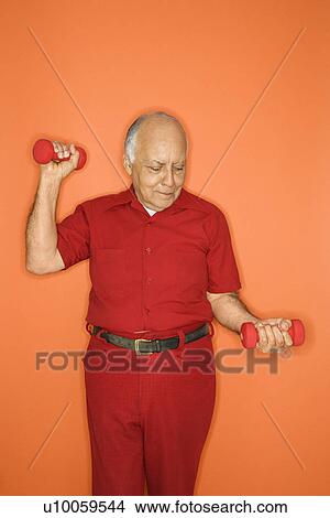 Picture - Mature adult Caucasian male lifting hand weights.. Fotosearch